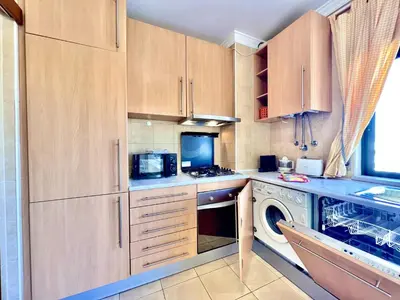 a kitchen with wooden cabinets and a washer and dryer at Albufeira Salgados Beach 6 by Homing in Albufeira
