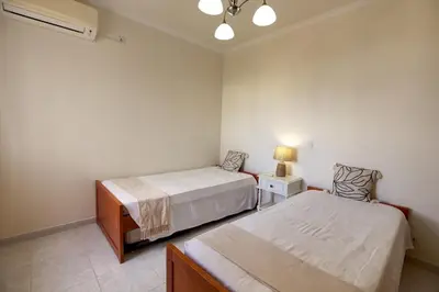 a bedroom with two beds and a lamp on a table at Quarteira Apartment with views in Quarteira