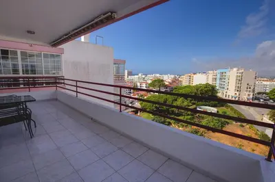 a balcony with a table and a view of a city at Quarteira Apartment with views in Quarteira