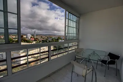 a balcony with a table and chairs and windows at Quarteira Apartment with views in Quarteira