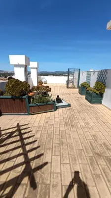 a shadow of a person on a pier with fruits and vegetables at Quarteira Apartment with views in Quarteira