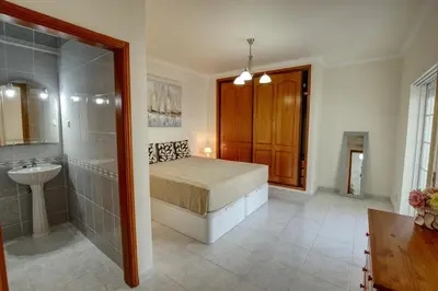 a bedroom with a bed and a shower and a sink at Quarteira Apartment with views in Quarteira