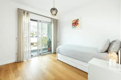 a white bedroom with a bed and a large window at Albufeira Green Dream Pool, Balcony & BBQ in Albufeira