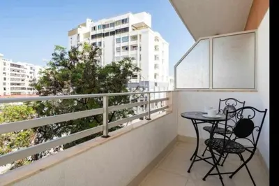 a balcony with a table and chairs on a balcony at Mello Apartamento renovado, praia de Quarteira in Quarteira