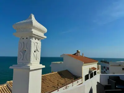 a room with two beds and a table with a lamp at Al Mare Ocean View in Albufeira