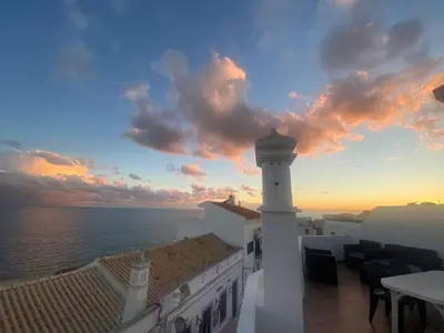 a balcony with a table and a bench on a roof at Al Mare Ocean View in Albufeira