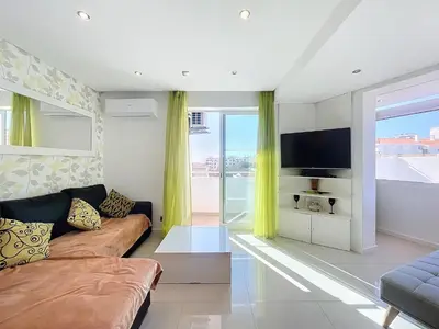 a living room with a couch and a tv at Paradise Near Old Town in Albufeira