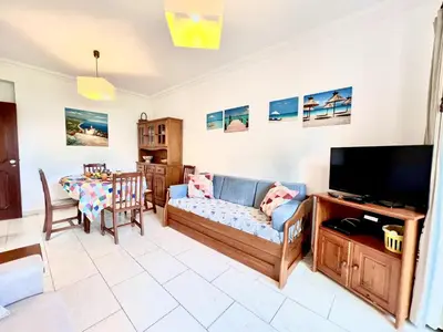 a living room with a couch and a television at Vilamoura Classic 2 with Pool by Homing in Quarteira