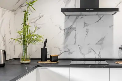 a kitchen with white marble walls and a counter top at Casa dos Avós - Faro Relax & Comfort in Faro