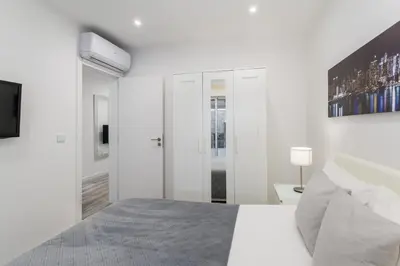 a white bedroom with a bed and a tv at Casa dos Avós - Faro Relax & Comfort in Faro