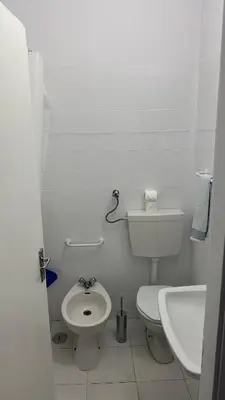 a white bathroom with a toilet and a sink at Sweet Dreams in Albufeira