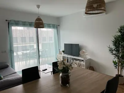 a living room with a table with a vase of flowers on it at Appartement T1 Faro in Faro