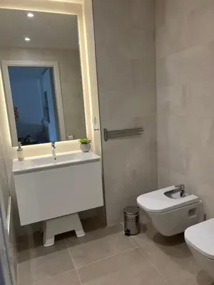 a bathroom with a sink and a toilet and a mirror at Appartement T1 Faro in Faro