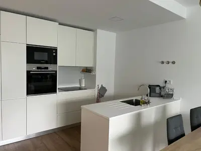 a white kitchen with white cabinets and a sink at Appartement T1 Faro in Faro
