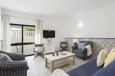 a living room with a couch and a table at Areias de São João 2BR Apartment - Shared Pool & Terrace, by Hopstays in Albufeira