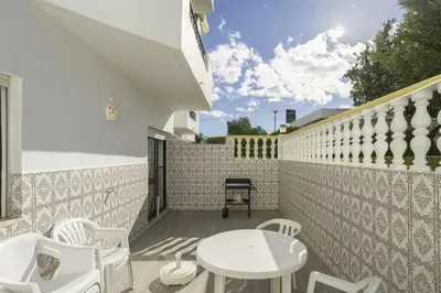 a patio with a table and chairs on a balcony at Areias de São João 2BR Apartment - Shared Pool & Terrace, by Hopstays in Albufeira