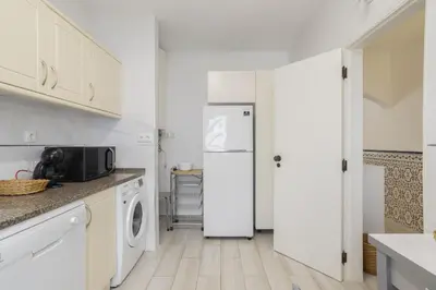 a kitchen with white cabinets and a refrigerator at Areias de São João 2BR Apartment - Shared Pool & Terrace, by Hopstays in Albufeira