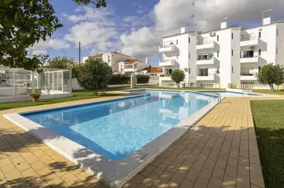 a swimming pool in front of a building at Areias de São João 2BR Apartment - Shared Pool & Terrace, by Hopstays in Albufeira