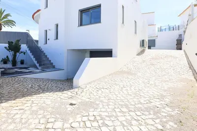 a white house with a stone driveway at Villa Soares - Centro Albufeira - For Families - BY BEDZY in Albufeira