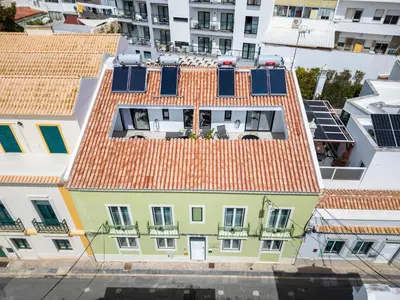 an overhead view of a building with solar panels on its roof at Roots Apartments in Faro