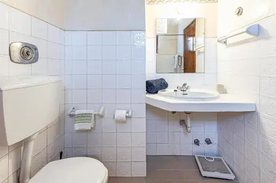 a white bathroom with a toilet and a sink at Casa Charlotte na Quinta da Balaia in Albufeira