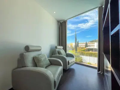 a living room with two chairs and a large window at Luxury 4-Suite Villa, Pool, Jacuzzi, Games Room in Albufeira