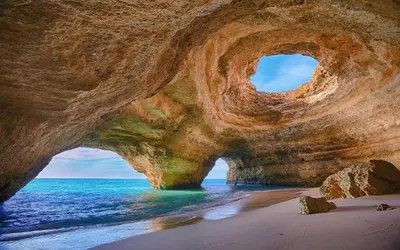 a rock formation on a beach with the ocean at Luxury 4-Suite Villa, Pool, Jacuzzi, Games Room in Albufeira