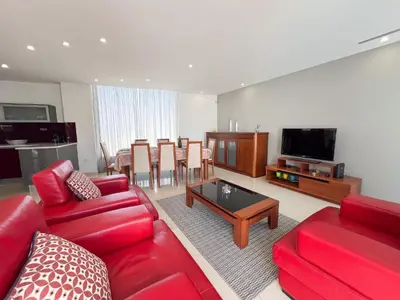 a living room with red furniture and a flat screen tv at Luxury 4-Suite Villa, Pool, Jacuzzi, Games Room in Albufeira