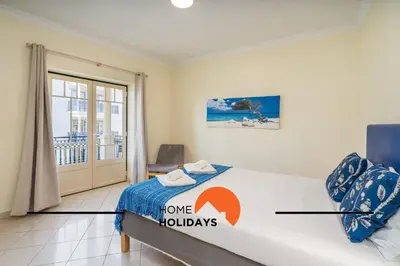 a bedroom with a bed with a home holidays sign on it at #269 T2 Bicos Flat R by Home Holidays in Albufeira