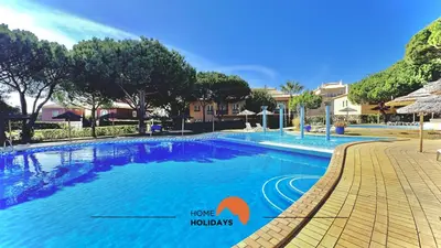 a large swimming pool with a sign that says have holidays at #269 T2 Bicos Flat R by Home Holidays in Albufeira
