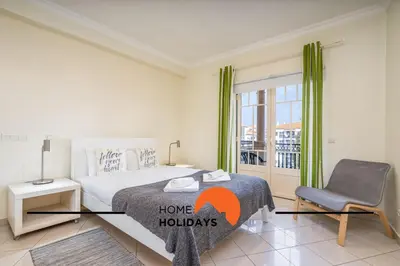 a bedroom with a bed and a chair and a window at #271 T2 Bicos Flat U by Home Holidays in Albufeira