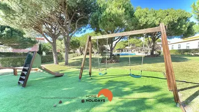 a playground with two swings in a park at #271 T2 Bicos Flat U by Home Holidays in Albufeira
