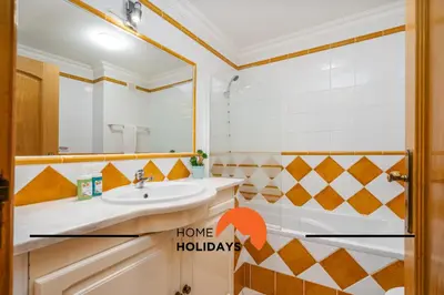 a swimming pool with two chairs and a umbrella at #272 T2 Bicos Flat J by Home Holidays in Albufeira