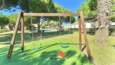 a swing set with two swings in a yard at #272 T2 Bicos Flat J by Home Holidays in Albufeira