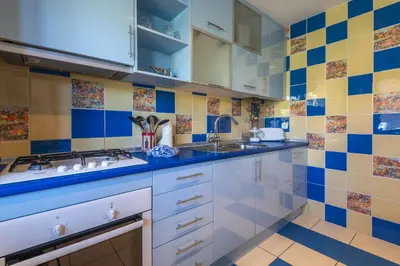 a kitchen with blue and yellow tiles on the wall at Marina Orada Apartment with Pool - 900m from the Beach in Albufeira