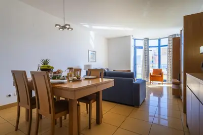 a living room with a table and a blue couch at Marina Orada Apartment with Pool - 900m from the Beach in Albufeira