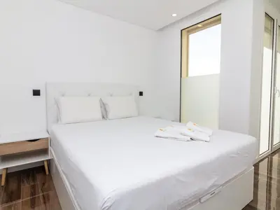 a large white bed in a room with a mirror at Eco Residence 05 House by Stay ici Algarve Holiday Rental in Albufeira