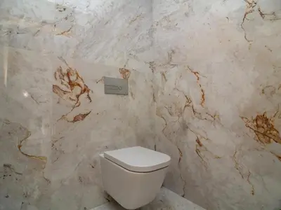 a bathroom with a white toilet and a marble wall at Eco Residence 05 House by Stay ici Algarve Holiday Rental in Albufeira