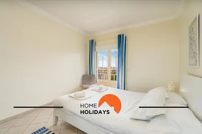 a bedroom with a bed with a home holidays sign on it at #274 T3 Bicos T by Home Holidays in Albufeira