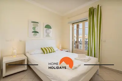 a bedroom with a bed with a home holidays sign on it at #274 T3 Bicos T by Home Holidays in Albufeira