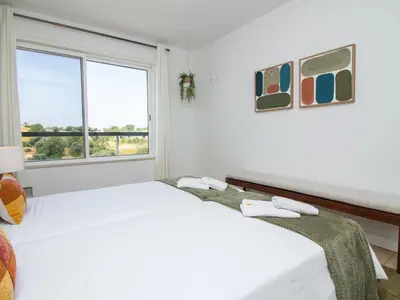 a white bedroom with a large bed and a window at Serenity 09 House by Stay ici Algarve Holiday Rental in Albufeira