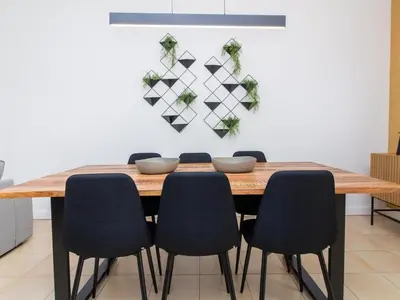 a dining room table with chairs and a wall at Serenity 09 House by Stay ici Algarve Holiday Rental in Albufeira