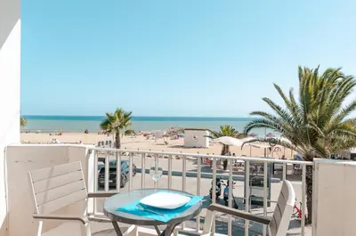 a balcony with a table and chairs and the beach at Sea Blue - Frente ao Mar in Quarteira