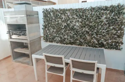 a table and two chairs in front of a wall at Sea Blue - Frente ao Mar in Quarteira