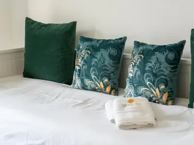 a white towel sitting on top of a bed with pillows at Green 3 Apartment by Stay ici Algarve Holiday Rental in Albufeira