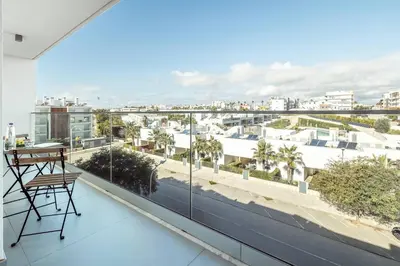 an apartment balcony with a white table and chairs at Penthouse Isabela VistaMar - Rooftop & Jacuzzi in Albufeira