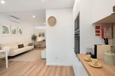 a kitchen and living room with a clock on the wall at Downtown Lux Apartment in Faro