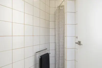 a shower in a white tiled bathroom at Casa Dona Vitória in Faro