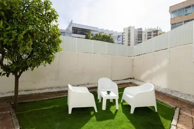 two white chairs and a table on a lawn at Casa Dona Vitória in Faro