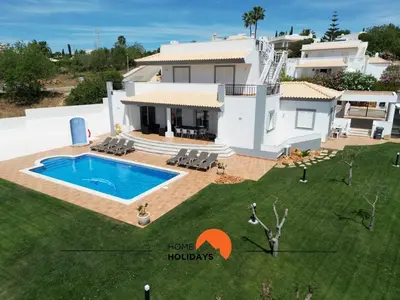 a villa with a swimming pool in front of a house at #297 Espaçosa Vivenda V5 by Home Holidays in Albufeira